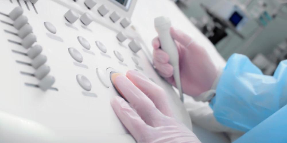 Clinician using handheld ultrasound transducer - EDM Medical Solutions