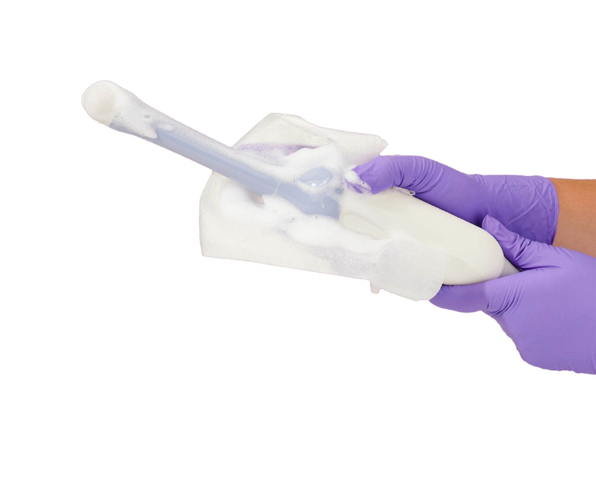 Clinician applying Tristel ULT Foam with a wipe to an ultrasound probe during high-level disinfection.